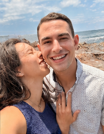 Caitie kissing Liam's cheek by the ocean